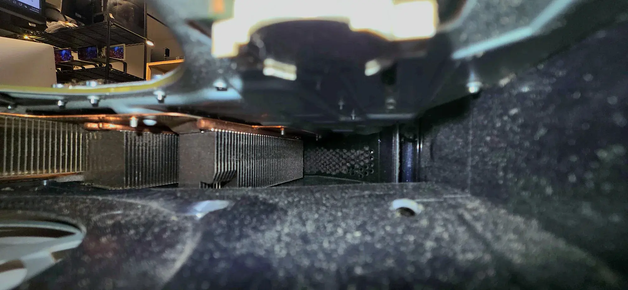 Inside an opened console, the heatsink fins and the case floor coated in fine grey dust